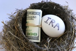 photo illustration of a nest egg with IRA written on it and a wad of money